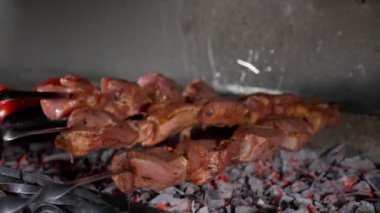 Şef mangal kömürünün üzerine etli şiş koyuyor..