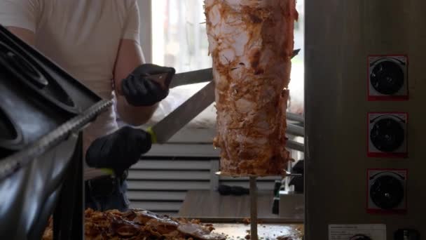 Un bucătar taie carnea cu un cuțit mare pentru a face shawarma, close-up . — Videoclip de stoc