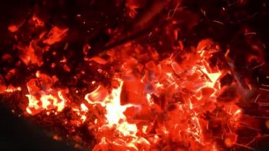 İtfaiyeci kömürü tandırda pokerle karıştırıyor.