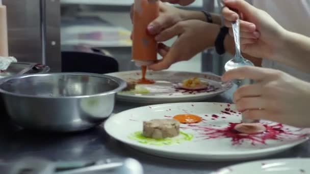 Два кухарі прикрашають закуску на кухні ресторану перед стравою її — стокове відео