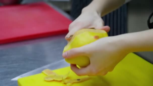 Lo chef irriconoscibile sbuccia una mela cotogna in cucina di ristorante — Video Stock