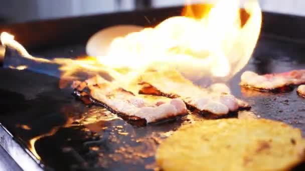 Szalonna húspogácsával hamburgerfőzéshez tűzzel a grillen.. — Stock videók