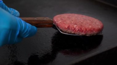 Hamburger pişiriyorum. Biftek ya da domuz pirzolası çeviren şefin yakın çekimi.