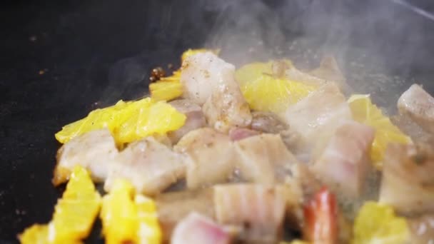 Seafood with peaces of orange are cooking on the grill, close-up in slow motion — Stock Video