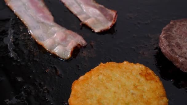 Fatias de bacon com carne patty para um hambúrguer batatas fritas na grelha. — Vídeo de Stock