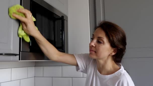 若い女性は台所で家具を掃除している. — ストック動画