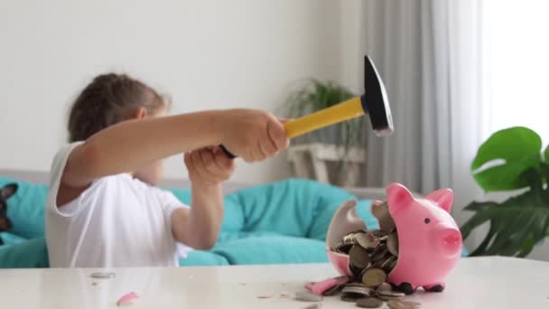 Klein kind meisje is crashen spaarvarken bank met hamer in slow motion — Stockvideo