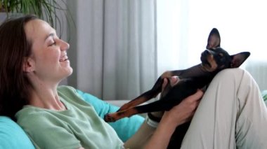 Kadın sahibi, sevimli bir köpeğe masaj yapıyor. Bacağına yalan söylüyor.