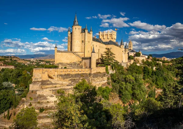 İspanya, Segovia 'daki Alcazar Sarayı' nın iki vadisinin manzarası. Orman vadisinin tepesinde, mavi gökyüzünde bulutlar var.