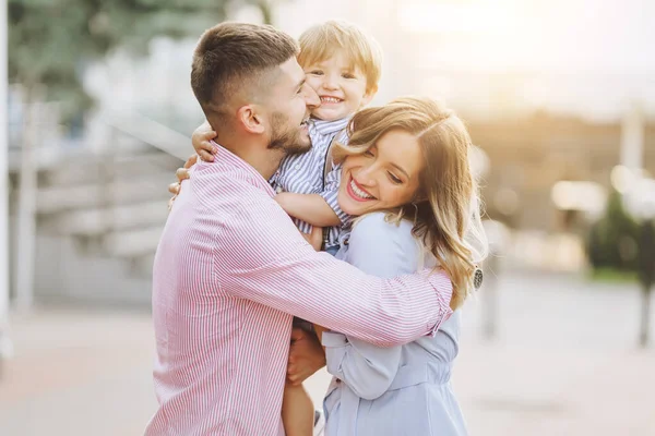 Mutlu aile: anne, baba, çocuklar gün batımında doğada oğul ve kız