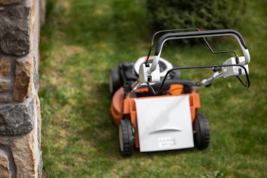 Güneşli bir bahar gününde yeni çim biçme makinesiyle çimen biçiyorum..