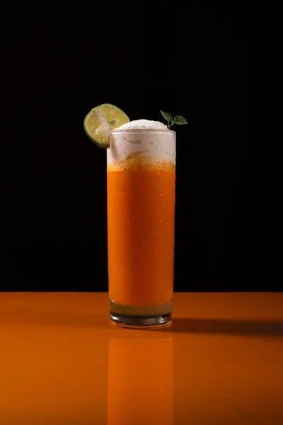 Turuncu masada duran taze bir portakal suyu.