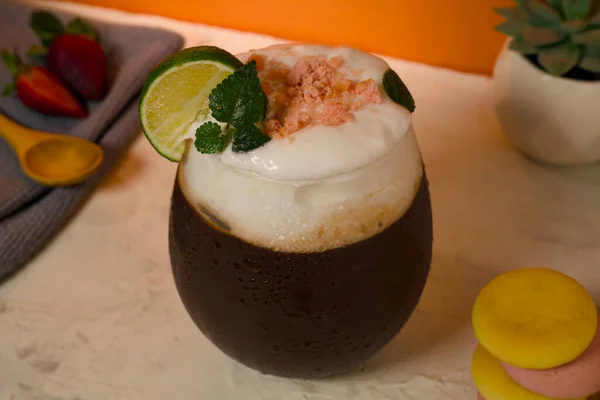 Orange juice with whipped cream topping and orange garnish