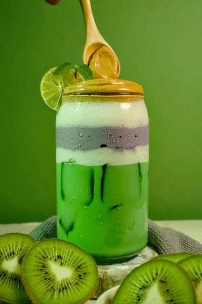 Delicious kiwi and taro smoothie with creamy layers and ice cubes, perfect for tropical summer refreshment.