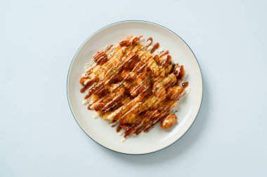 Üzerine mayonez, mozzarella ve peynir konmuş kızarmış patates, beyaz tabakta servis ediliyor. yassı gıda konsepti