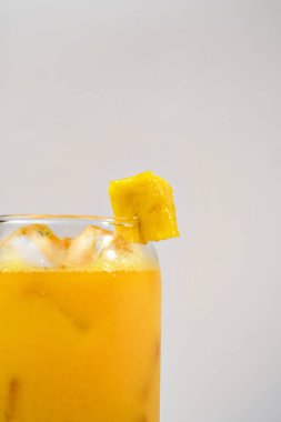Bir bardakta çeyrek mango suyu ve etrafında da bir fotokopi alanı. Vitamin zengini ve sağlıklı beslenme kavramı