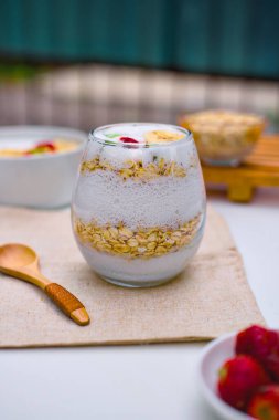 Lezzetli ve sağlıklı bir kase yulaf ezmesi üzerine cömertçe dilimlenmiş muz, canlı çilekler ve besleyici bir sabah yemeği için hazır kivi parçaları..