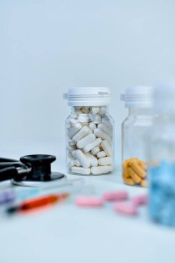 Sağlık hizmetleri için tıbbi gereçlerin yanı sıra beyaz haplar içeren reçeteli bir şişeye yakın plan..