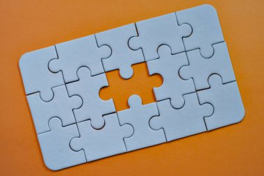 Gri yapboz montajı, son ve kritik parçayı gerektiren önemli bir boşluğu vurguluyor..