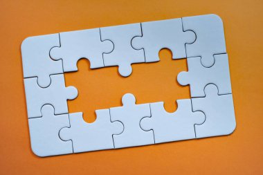 Beyaz yapboz parçaları iki eksik merkez bölümü ile bir sınır şekli oluşturur.