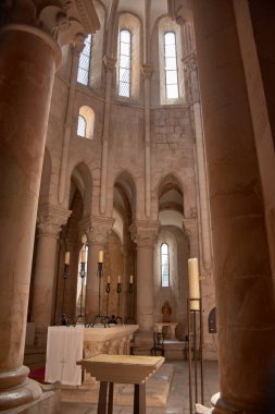 The altar of the Alcobaca Monastery is framed by columns Romanesque carved stone vaults, under a high vault that channels natural light from the upper windows.  