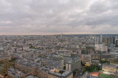 Eyfel Kulesi 'nin tepesinden Paris' in panoramik manzarası Alacakaranlık 'a kadar uzanır. Aydınlanmış sokaklar ve sıcak ışıkla yıkanmış klasik binalar. Derin mavi gökyüzü, şehrin zarafetini arttıran sakin bir atmosfer yaratır..