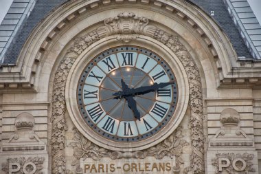 Müze d 'Orsay' in anıtsal saati, Roma rakamları ve taşa oyulmuş heykel çerçevesiyle ön cephesinin tam ortasında yer alır. 