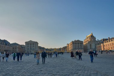 Versailles, Fransa - 12 Ekim 2025, Versailles Sarayı simetrik Barok mimarisi tarafından çerçevelenmiş anıtsal cephesi, yaldızlı korkulukları ve kaldırım taşı karesi ile kendini sunar..
