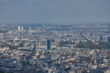 Montparnasse Kulesi 'nin tepesinden Paris' in Latin Mahallesi 'nin panoramik bir manzarası yükselir. Pantheon neoklasik kubbesiyle üniformalı çatıların arasında göze çarpar. Arka planda, Zamansky Kulesi üniversitenin sembolü olarak yükseliyor. 