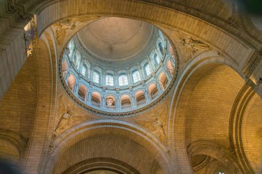 Paris, Fransa - 14 Ekim 2025, Montmartre 'deki Sacre-Corur Bazilikası' nın içi, merkezi kubbeyi çerçeveleyen süslü mahzenler, klasik sütunlar ve yaldızlı fresklerle donatılmış kutsal ve ruhani bir atmosferi ortaya çıkarmaktadır. lig