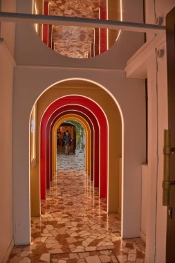 Paris, Fransa - 14 Ekim 2025 Pierre Herme Paris butik mağazasının içi sıcak tonlarda eşmerkezli kemerlerle dolu bir koridorla şaşırtıcı bir şekilde aydınlatılıyor..  