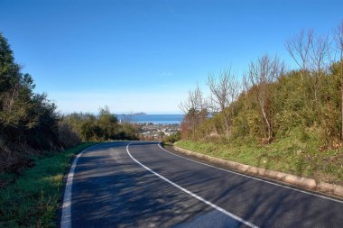 Bu fotoğraf İspanya 'nın Vigo kentindeki San Andres de Comesana' nın bereketli manzaraları boyunca uzanan pitoresk bir dağ yolunu yakalar. Yılan yolu, izleyicinin gözünü, sakin suların olduğu Ria de Vigo 'nun nefes kesici arka planına yönlendirir.
