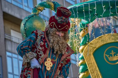 Vigo, Pontevedra, İspanya, 5 Ocak 2026, Kral Gaspar görkemli kırmızı ve yeşil kadife bir takım elbise ve karmaşık altın işlemeli ve imzası kıvırcık sarı sakalı ile resmedilmiştir..