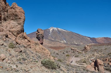 Teide, Tenerife, 13 Ocak 2026, bir grup ziyaretçi, Teide Dağı 'nın eteklerinde uzanan kireç kumu ve bazalt kayaları boyunca yürür..