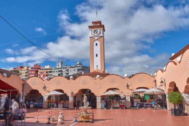 Santa Cruz de Tenerife, İspanya, 16 Ocak 2026, Santa Cruz de Tenerife pazarının merkez avlusu beyaz bulutların altında ince saat kulesini çerçeveleyen somon renkli kemerlerin uyumlu bir mimarisini sergiliyor..