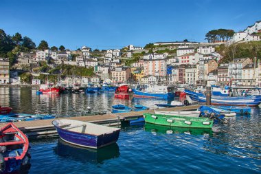 Luarca, Asturias, İspanya; 29 Mart 2025: İspanya 'nın Asturias kentindeki Luarca limanı, güneşli bir günde hem eğlence hem de balıkçı tekneleriyle dolu. Açık mavi sular renkli damarları yansıtıyor ve canlı bir manzara yaratıyor. Resim Vurgulaması