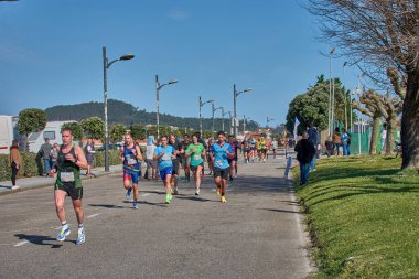 Nigran, Pontevedra, İspanya; 6 Nisan 2025; Bu yakın plan, İspanya 'nın Nigran kentinden geçerken yıllık Vigo-Bayona maratonuna katılan koşucuların enerjilerini ve kararlılıklarını yakalar. Fotoğraf yarışın şiddetini vurguluyor ve...