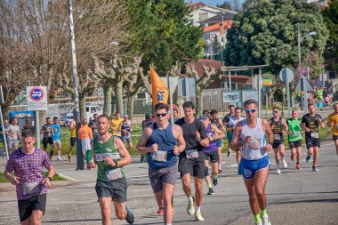 Nigran, Pontevedra, İspanya; 6 Nisan 2025; Bu yakın plan, İspanya 'nın Nigran kentinden geçerken yıllık Vigo-Bayona maratonuna katılan koşucuların enerjilerini ve kararlılıklarını yakalar. Fotoğraf yarışın şiddetini vurguluyor ve...