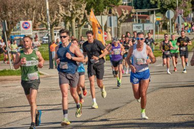 Nigran, Pontevedra, İspanya; 6 Nisan 2025; Bu yakın plan, İspanya 'nın Nigran kentinden geçerken yıllık Vigo-Bayona maratonuna katılan koşucuların enerjilerini ve kararlılıklarını yakalar. Fotoğraf yarışın şiddetini vurguluyor ve...