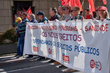 İspanya 'nın Vigo kentinde düzenlenen 1 Mayıs Uluslararası İşçi Bayramı gösterisine büyük bir grup insan katılıyor. Kalabalık, işçi haklarını savunmak amacıyla kentin sokaklarında yürürken renkli bayraklar ve afişler görülüyor
