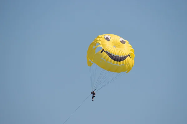 Renkli bir paraşüt üzerinde güneş doğarken uçan adam — Stok fotoğraf