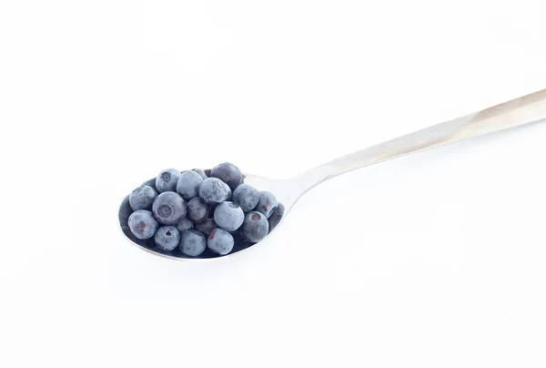 Ripe blueberries in a metal spoon on white background — Stock Photo, Image