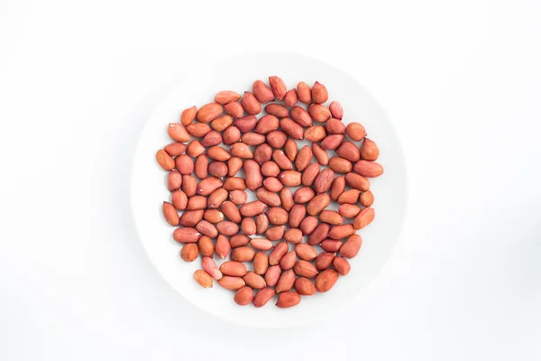 Cacahuetes crudos sobre un plato fondo blanco — Foto de Stock