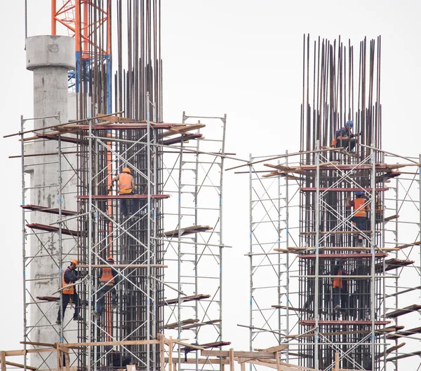 Bouwers bezig met de bouw van een groot gebouw Rechtenvrije Stockafbeeldingen