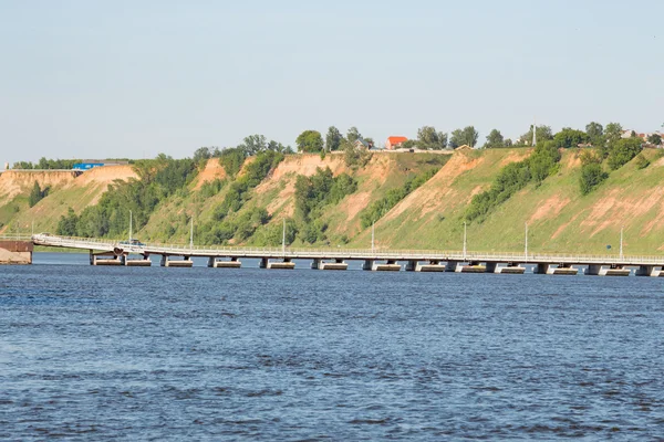 Bridge across the wide river and the high bank — Stock Photo, Image