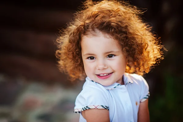 Little girl with curly hair smiles — Stock Photo, Image