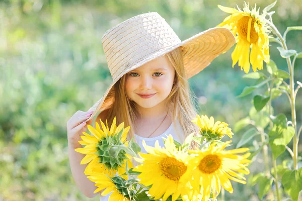 Schattig meisje in zonnebloemen — Stockfoto