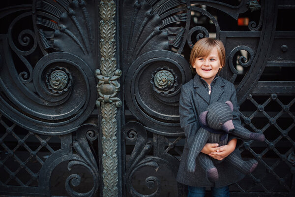 Little boy by forged gates