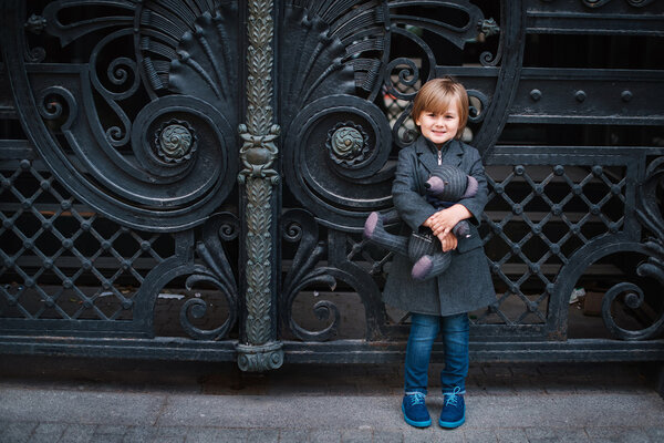 Little boy by forged gates