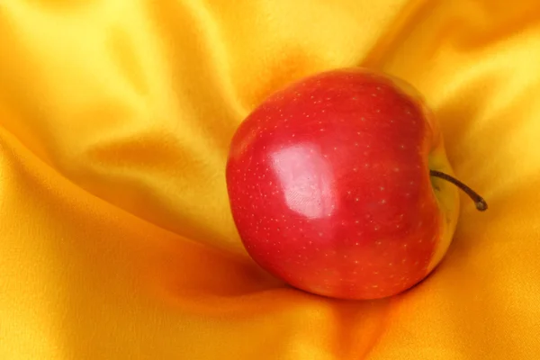 Apple on the yellow tablecloth in sunlight — Stock Photo, Image